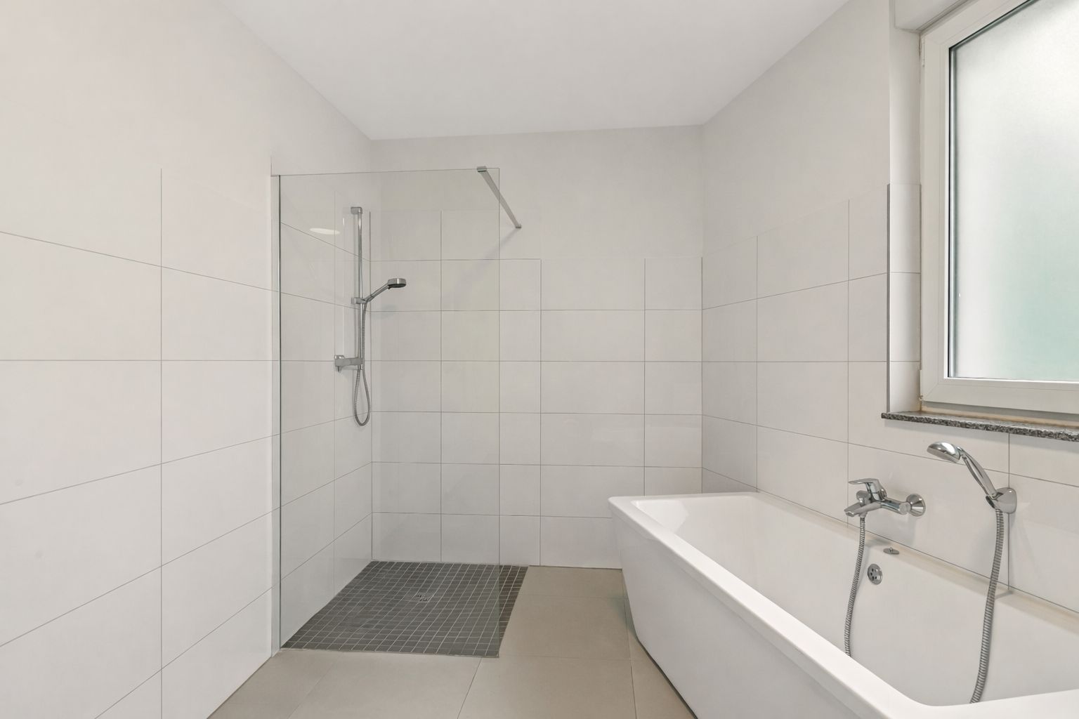 Modernes Badezimmer mit bodengleicher Dusche, Badewanne und Fenster.