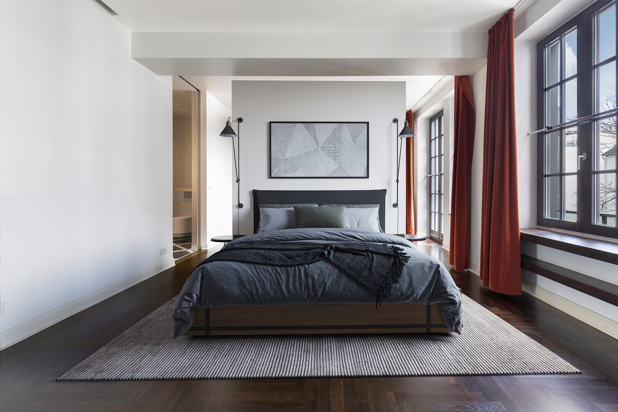 Modernes Schlafzimmer mit großem Bett, zwei Fenstern und roten Vorhängen.