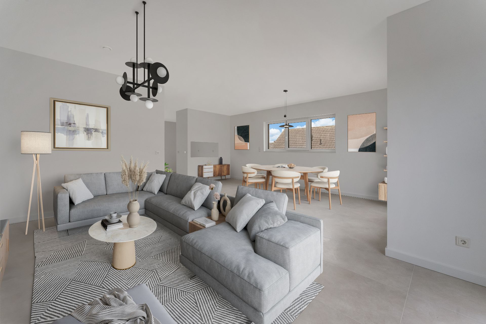 Modernes Wohnzimmer mit grauem Sofa, rundem Tisch und Essbereich mit sechs Stühlen im Hintergrund.