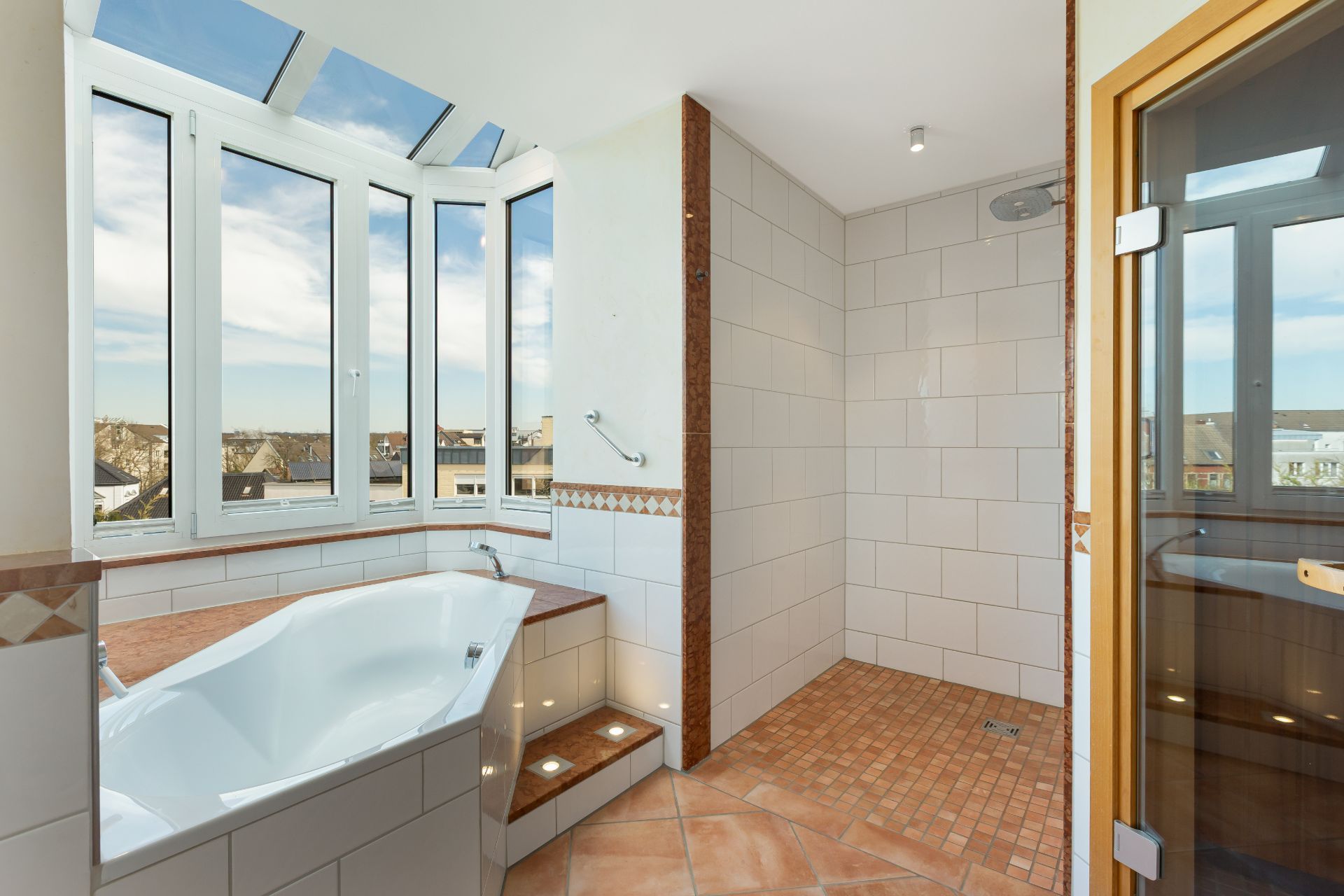 Modernes Badezimmer mit Badewanne, großer Dusche, Sauna und Panoramafenster.