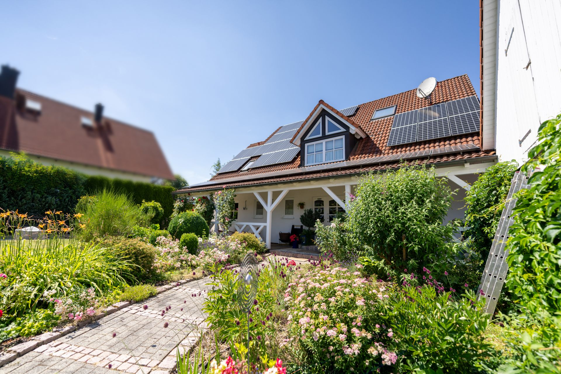 Einfamilienhaus mit Solarpanels auf dem Dach und gepflegtem Garten im Vordergrund.