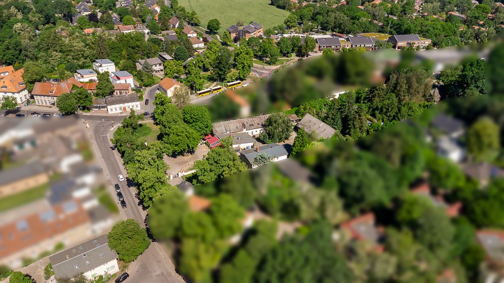 Luftbild einer Wohngegend mit Häusern, Straßen und vielen Bäumen.