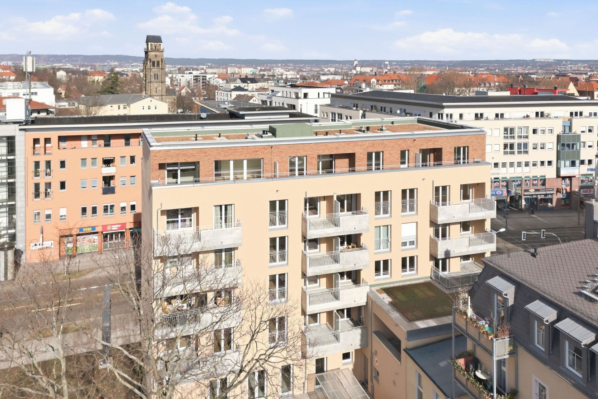 Mehrstöckiges Wohngebäude mit Balkonen in einer städtischen Umgebung bei Tageslicht.