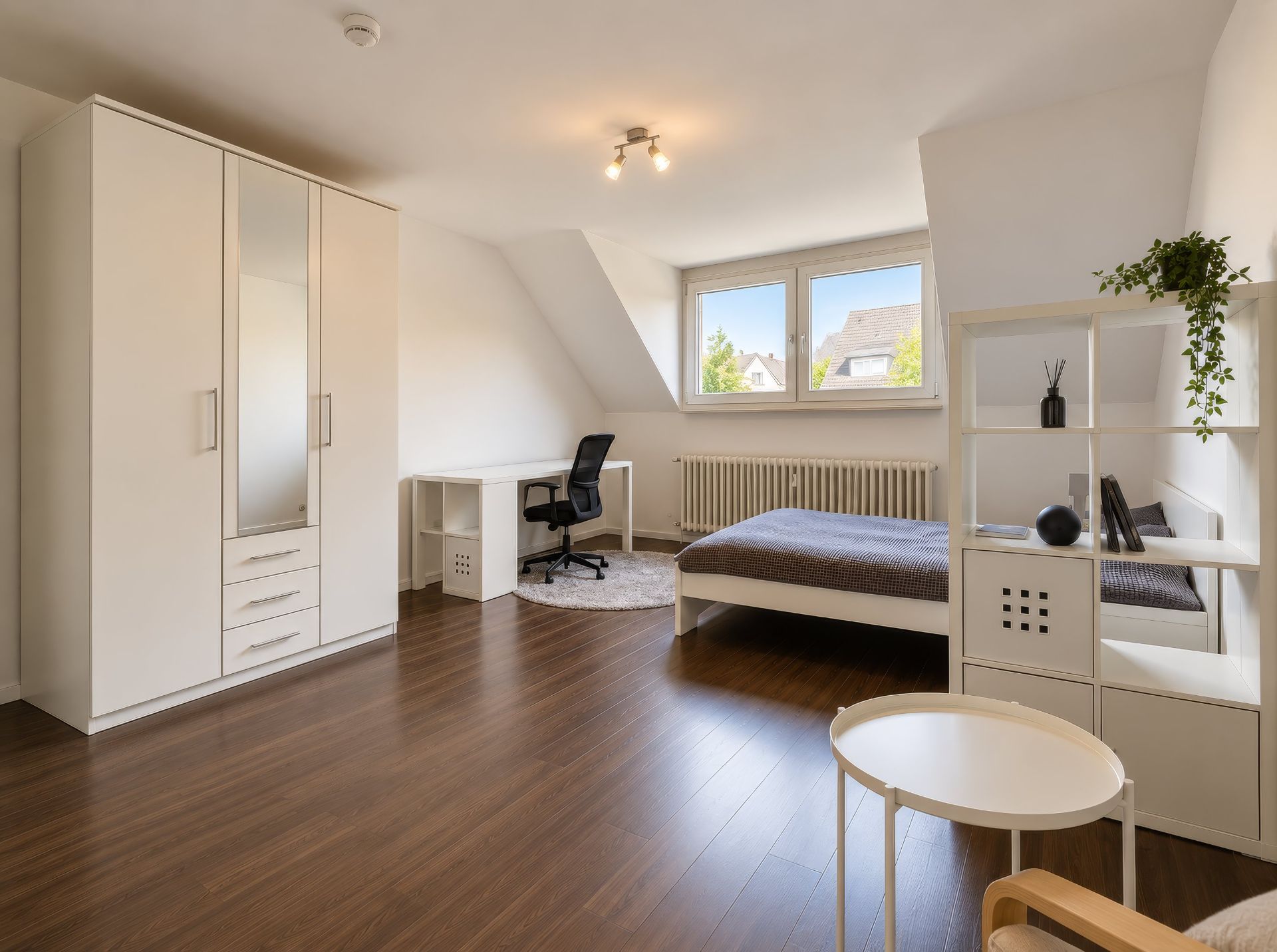 Modernes Schlafzimmer mit Bett, Schreibtisch, Kleiderschrank und Regal auf Holzboden.