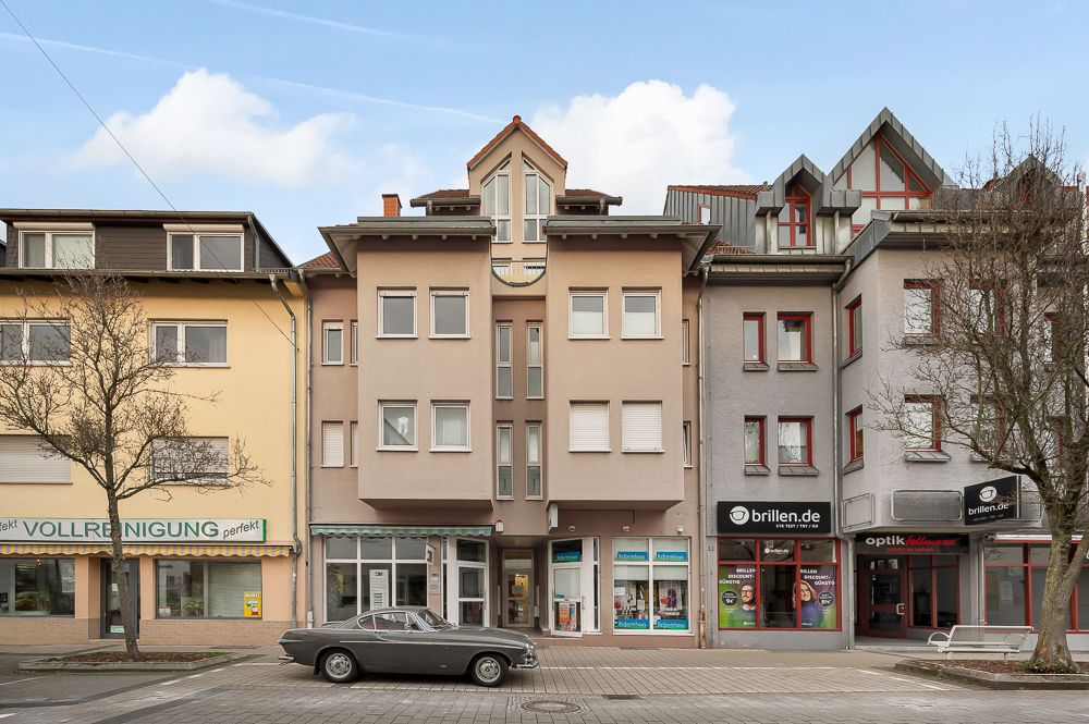 Mehrstöckiges Wohn- und Geschäftshaus mit Läden im Erdgeschoss und Wohnungen darüber.