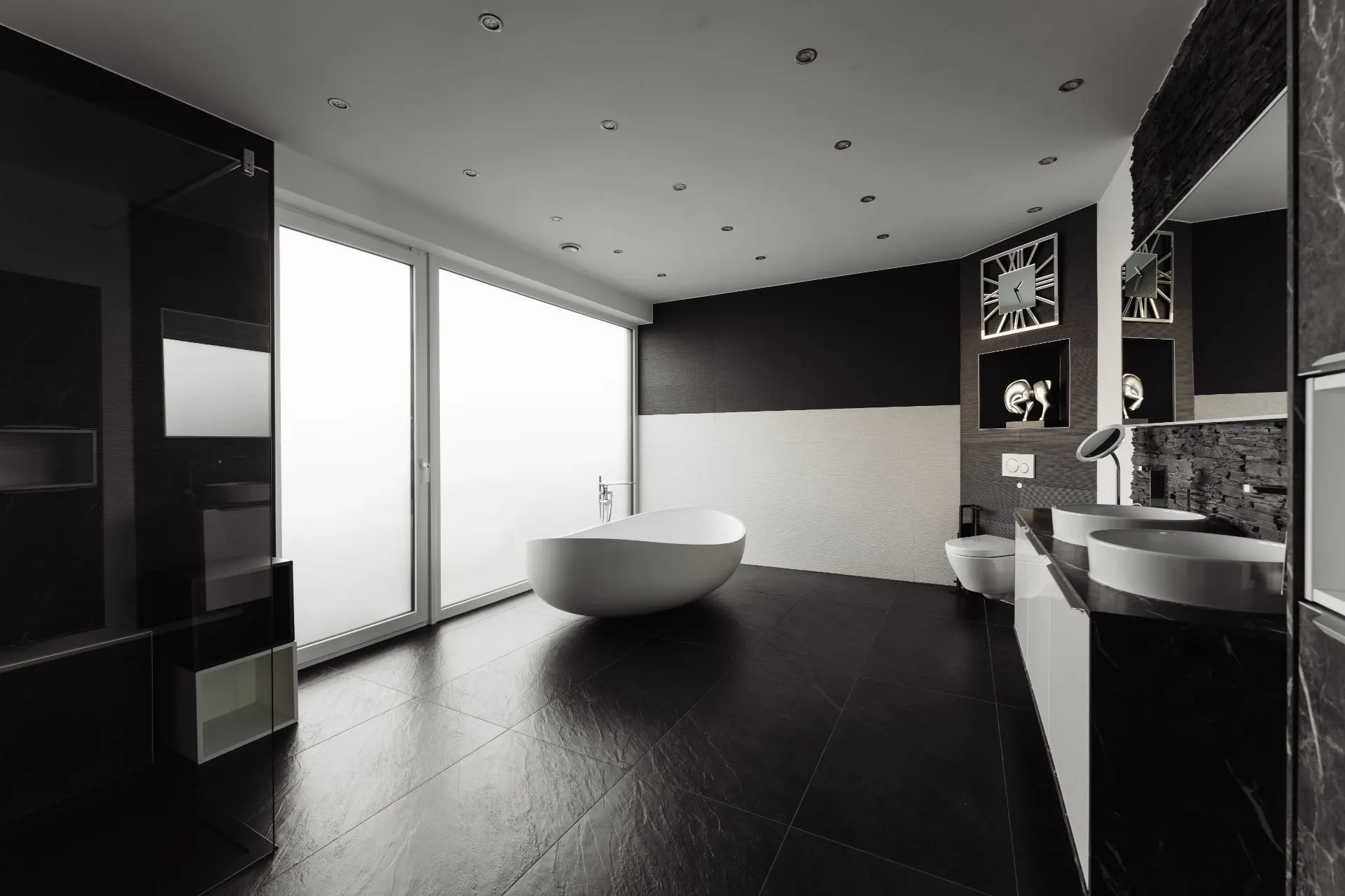 Modernes Badezimmer mit freistehender Badewanne, Doppelwaschbecken und großen Fensterflächen.