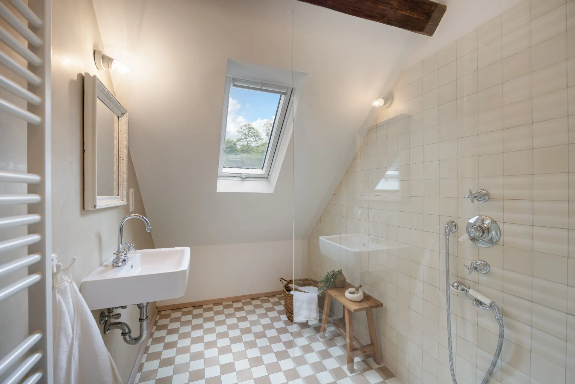 Helles Badezimmer mit Dachfenster, Waschbecken, Dusche und gefliestem Boden.