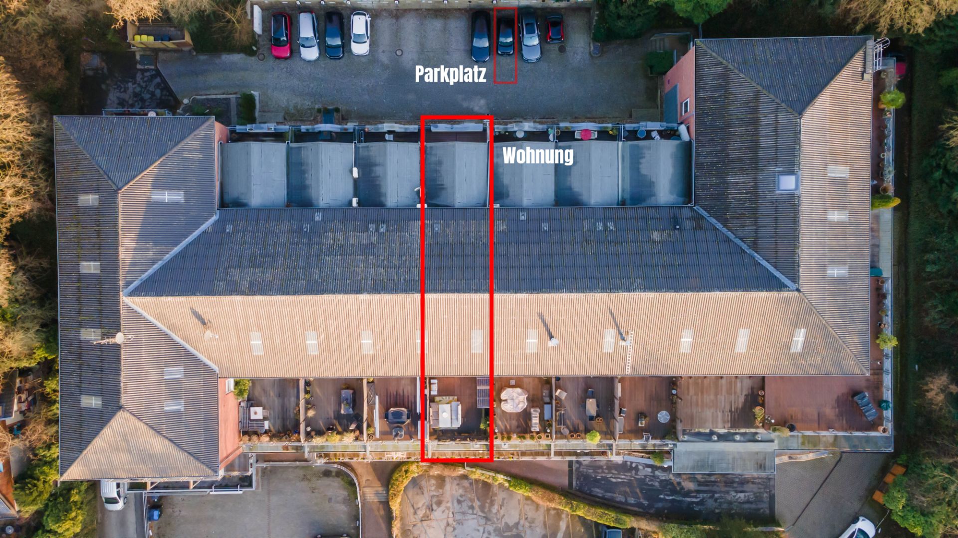 Luftaufnahme eines Wohngebäudes mit markierter Wohnung und Parkplatz.