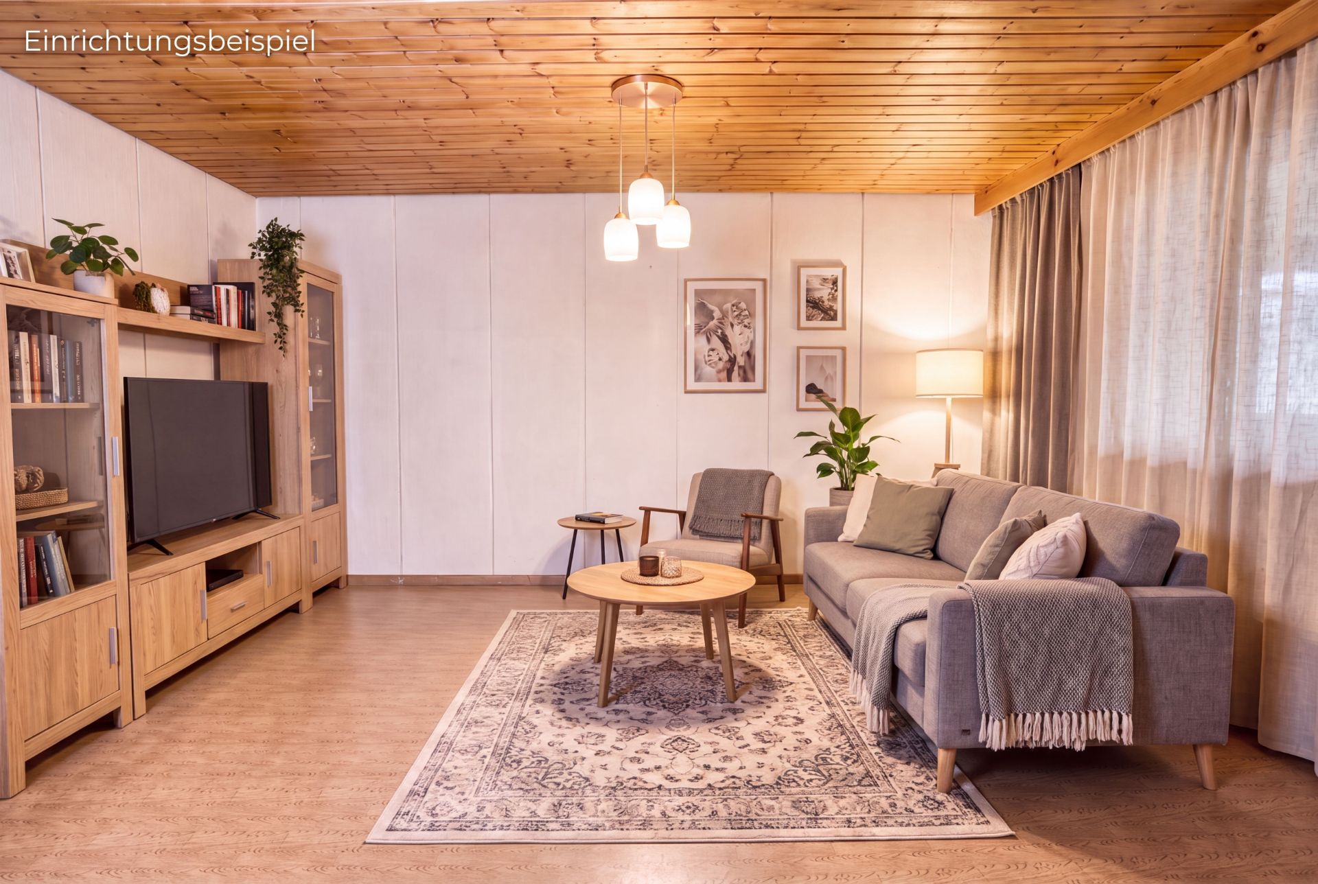 Gemütliches Wohnzimmer mit grauem Sofa, Holzregalen, Teppich und TV, warme Beleuchtung.
