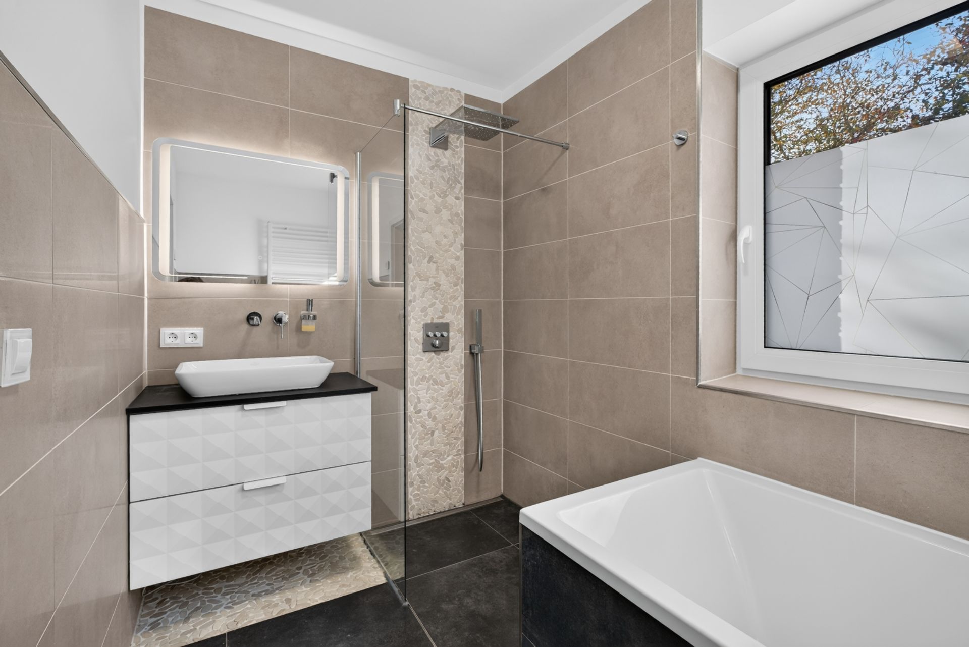 Modernes Badezimmer mit begehbarer Dusche, Waschbecken, Spiegel, Badewanne und Fenster.