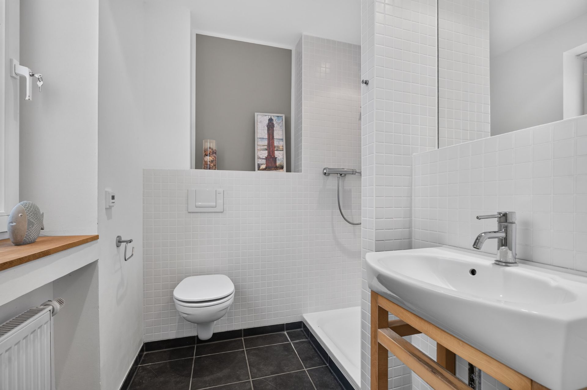Modernes Bad mit Dusche, Waschbecken, WC und Fensterbank mit Dekoration.