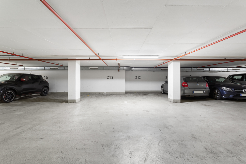 Tiefgaragenstellplätze mit mehreren geparkten Autos und freien Parkflächen.