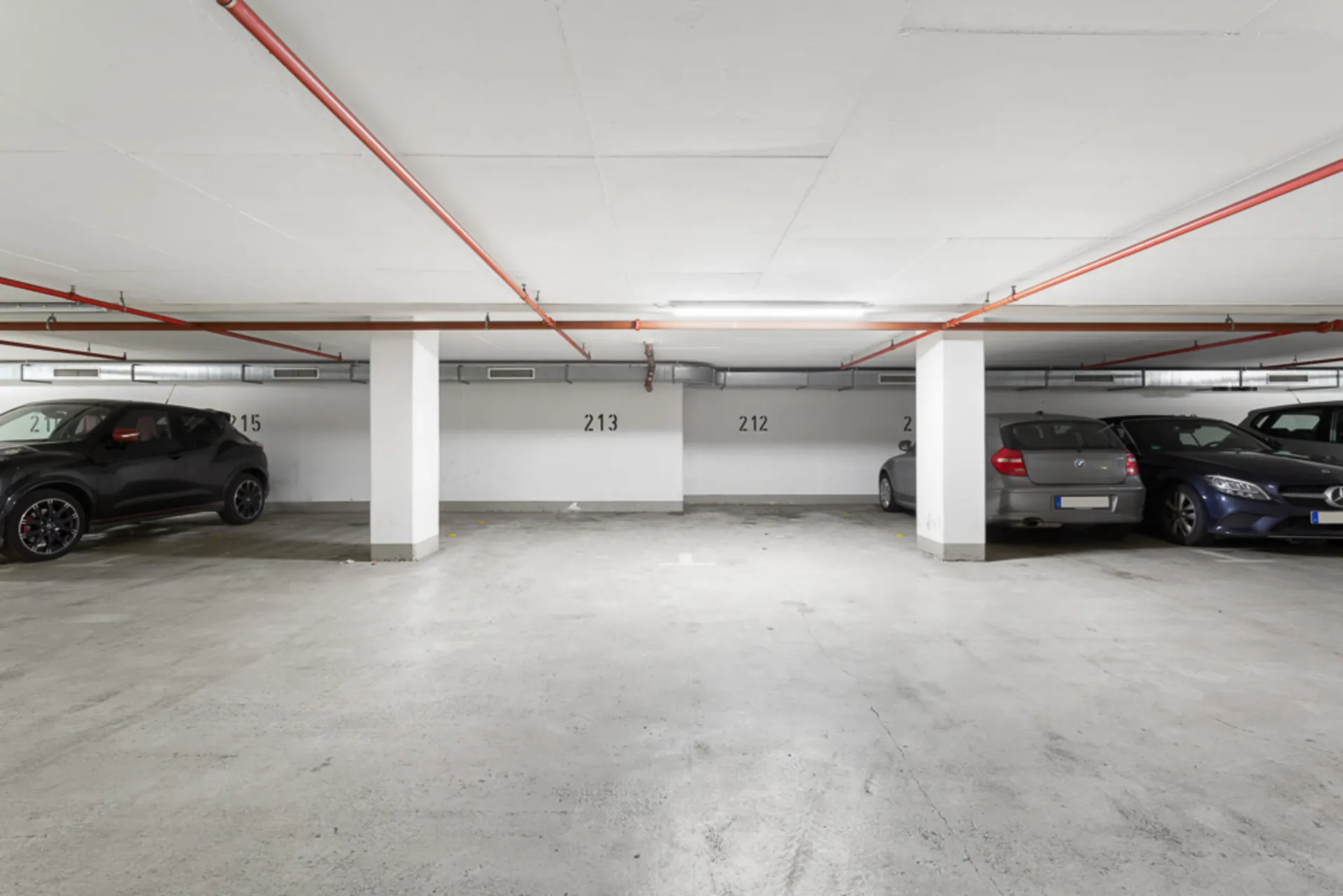 Tiefgaragenstellplätze mit mehreren geparkten Autos und freien Parkflächen.