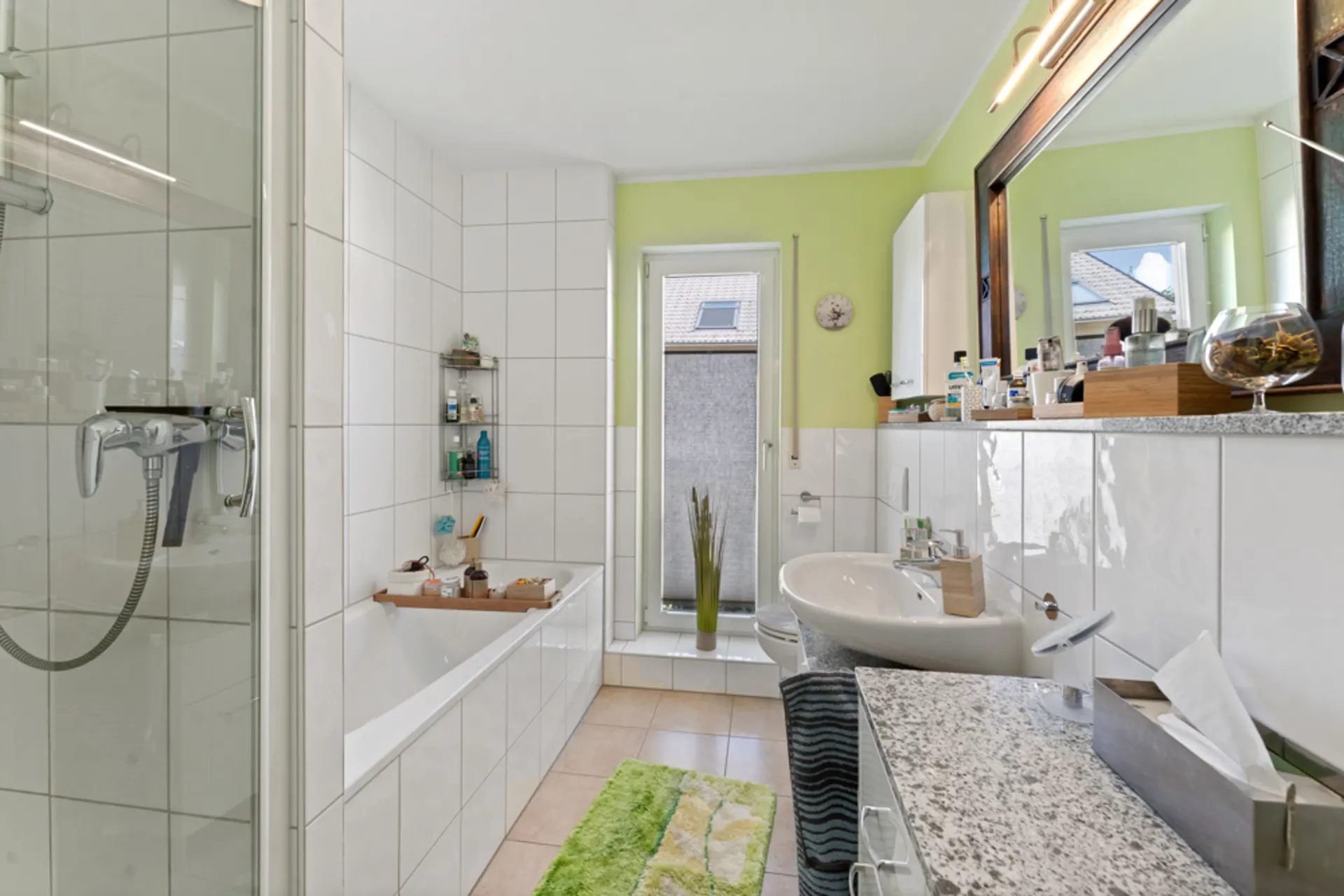 Modernes Badezimmer mit Badewanne, Dusche, Waschbecken und großem Spiegel.
