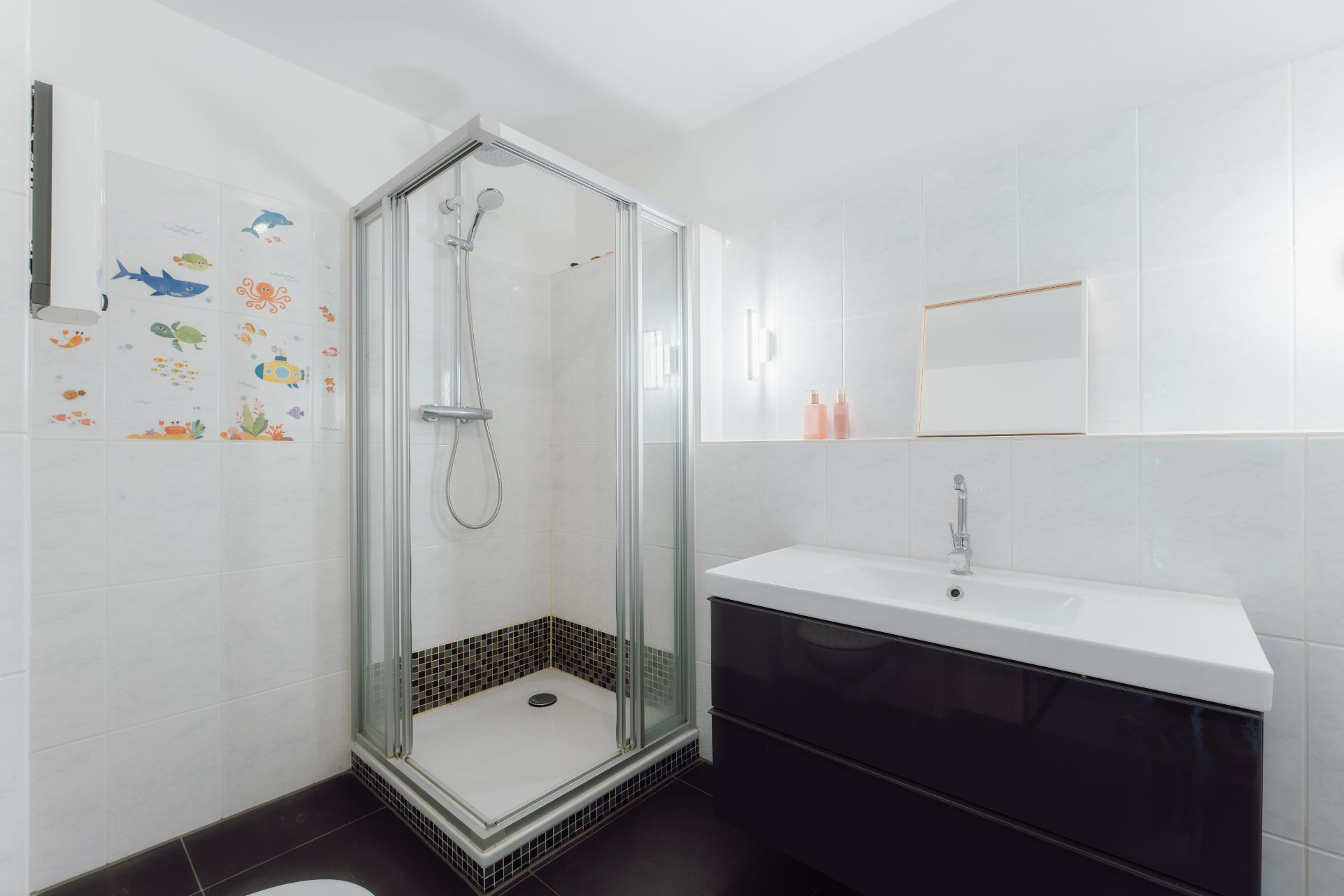 Modernes Badezimmer mit Eckdusche und Waschbecken, Tiersticker an der Duschwand.