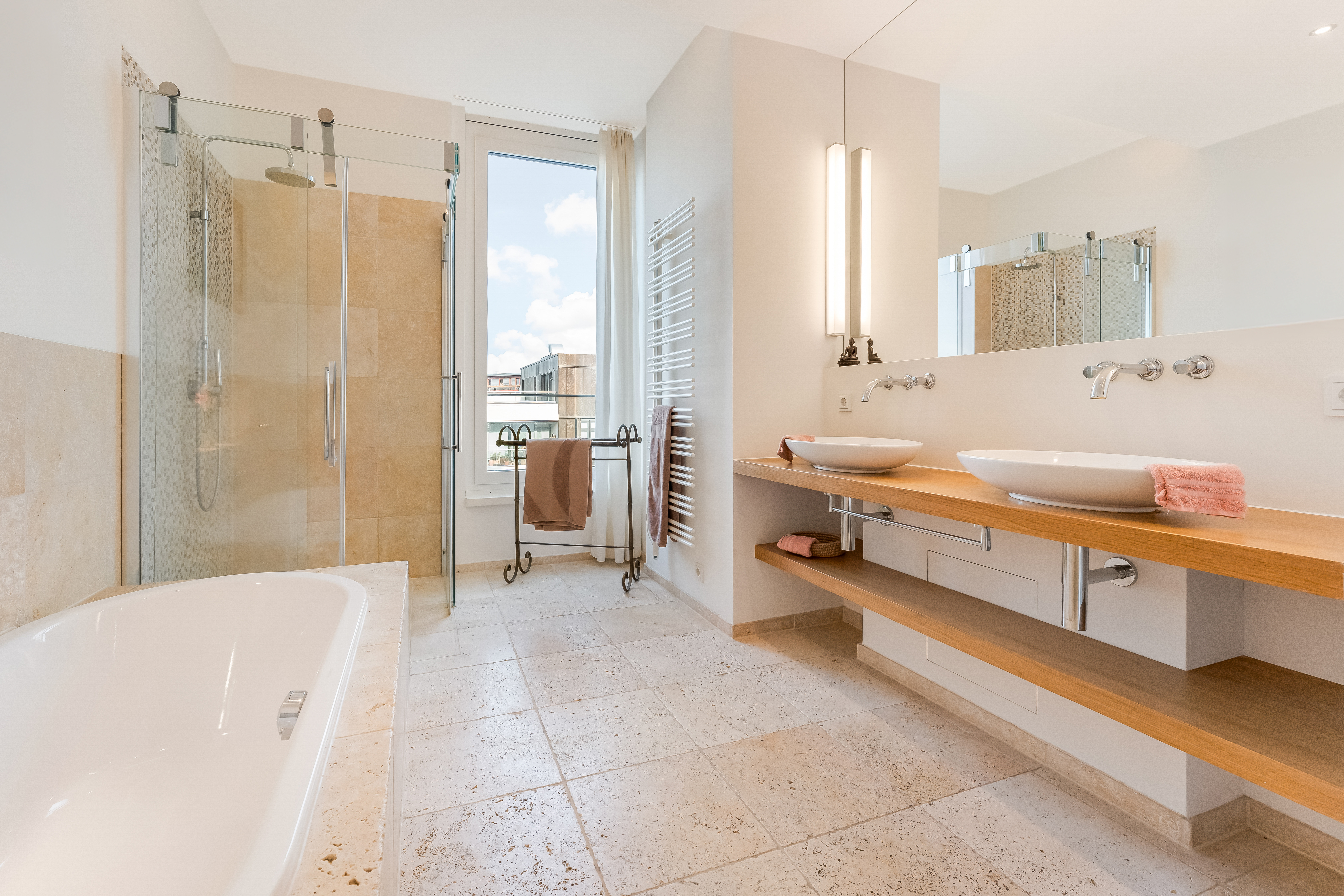 Modernes Badezimmer mit großer Dusche, Badewanne, Doppelwaschbecken und Fenster.