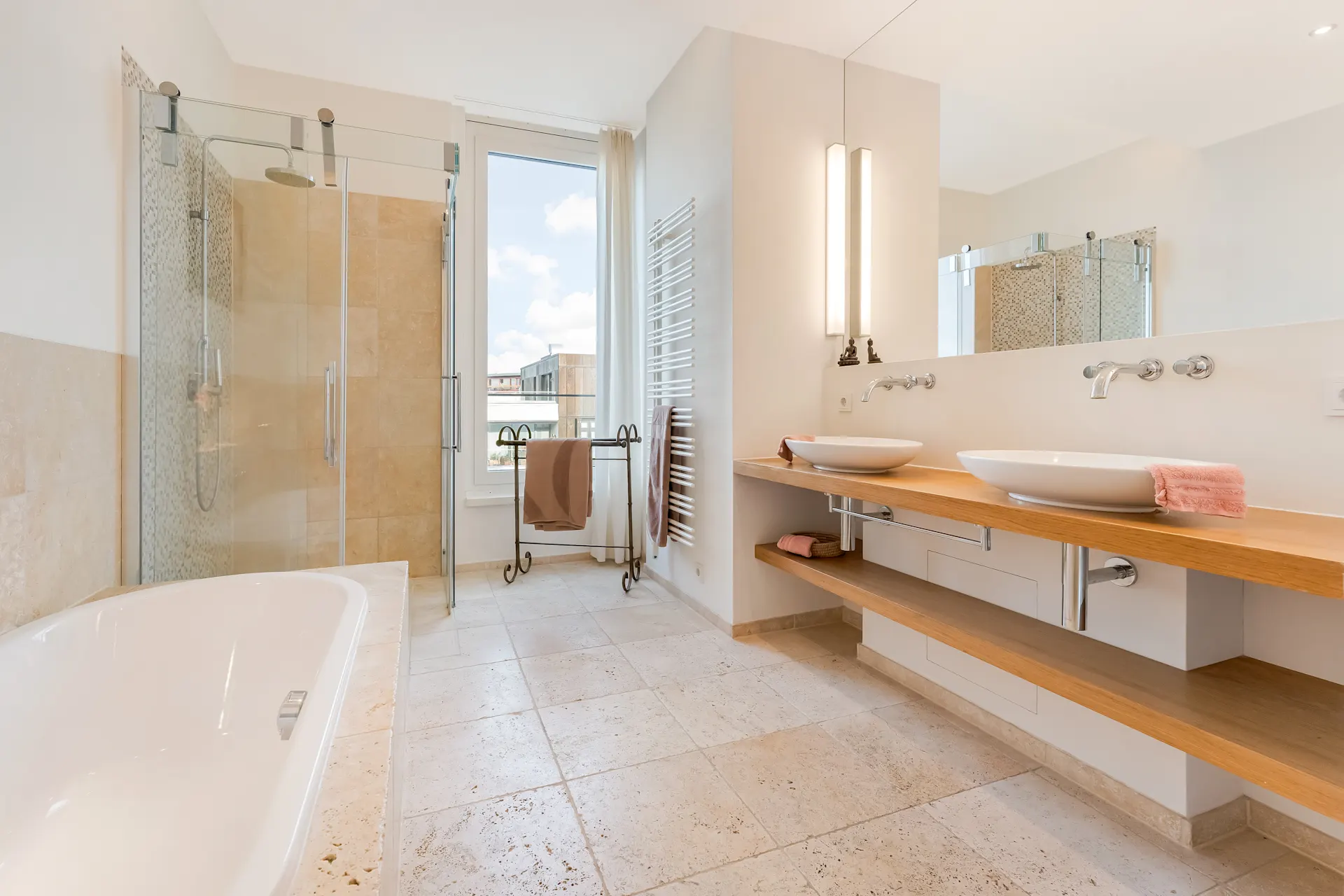 Modernes Badezimmer mit großer Dusche, Badewanne, Doppelwaschbecken und Fenster.