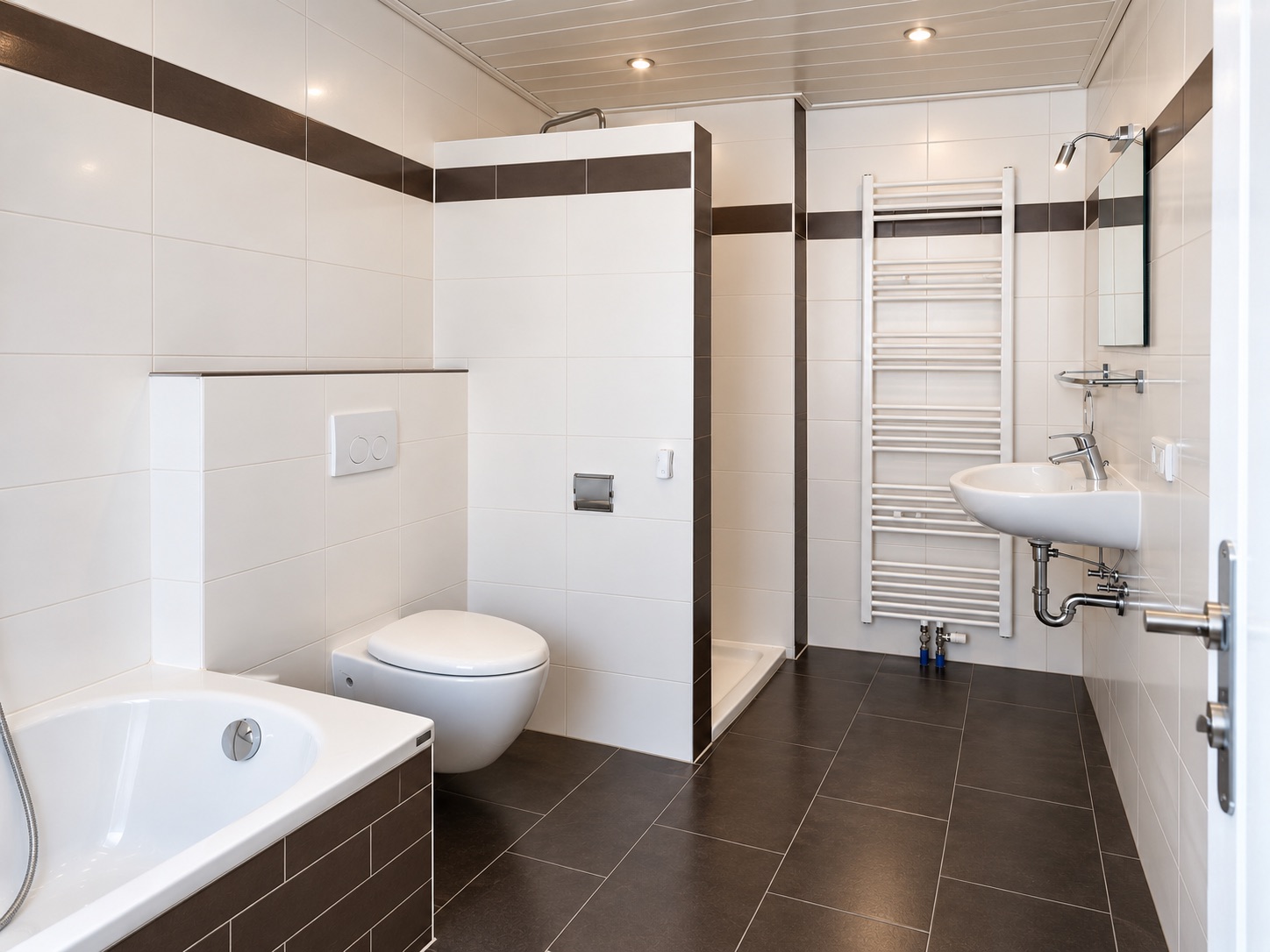 Modernes Badezimmer mit Badewanne, Toilette, Dusche, Waschbecken und Handtuchheizkörper.