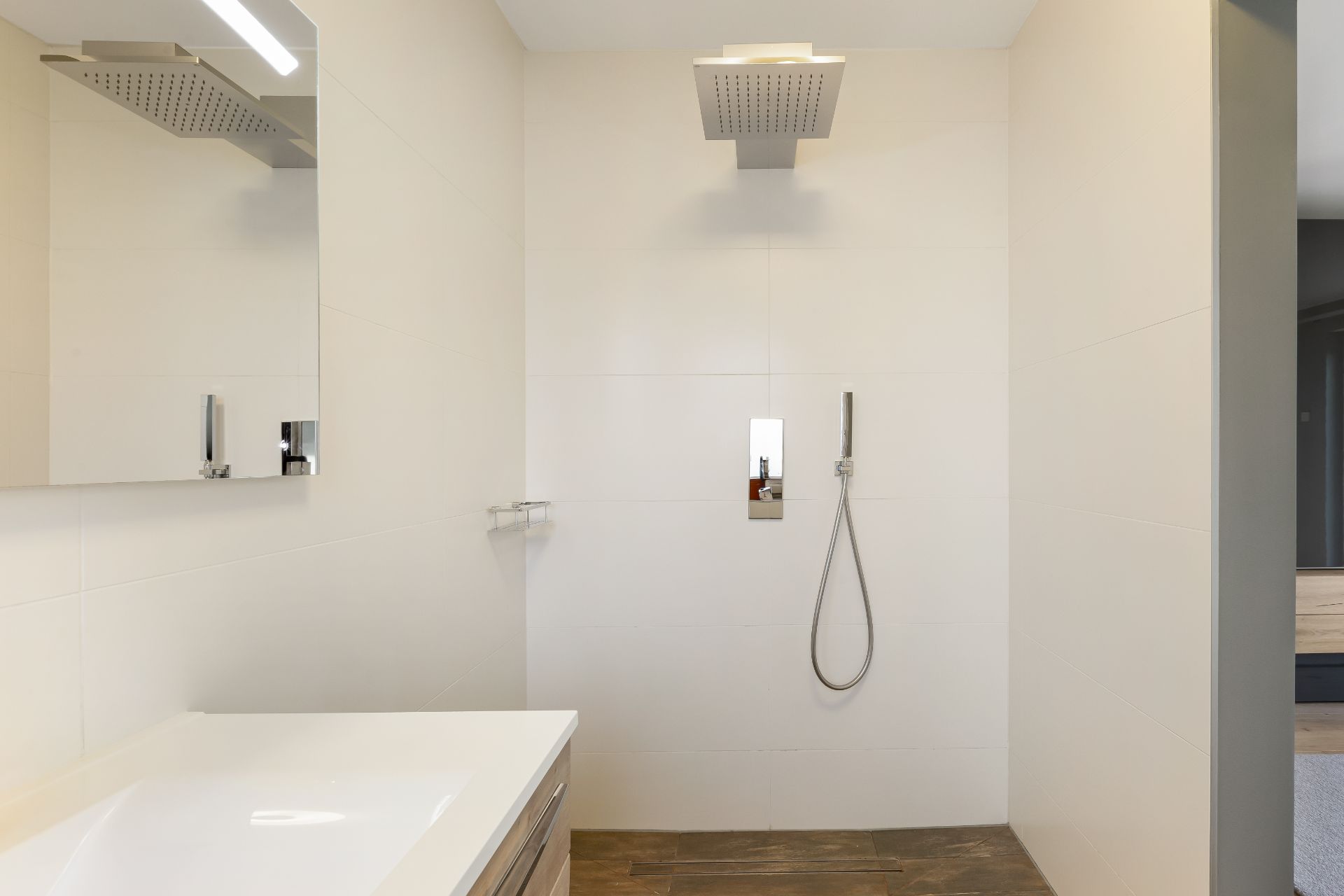 Modernes Badezimmer mit großer begehbarer Dusche und quadratischem Duschkopf.