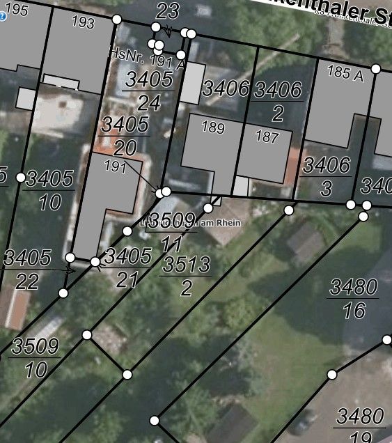 Luftaufnahme von Grundstücksparzellen mit Hausnummern und Grenzen, teils mit Gebäuden.