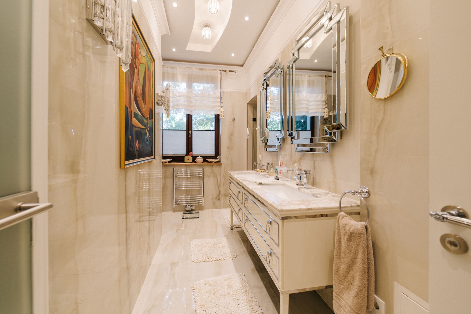 Modernes Badezimmer mit Doppelwaschbecken, großem Spiegel, Fenstern und dekorativer Beleuchtung.