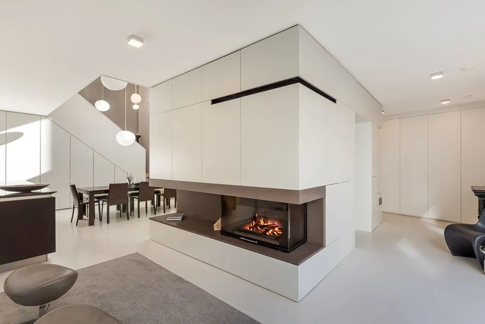 Modernes Wohnzimmer mit Kamin, Essbereich und weißen Wänden.