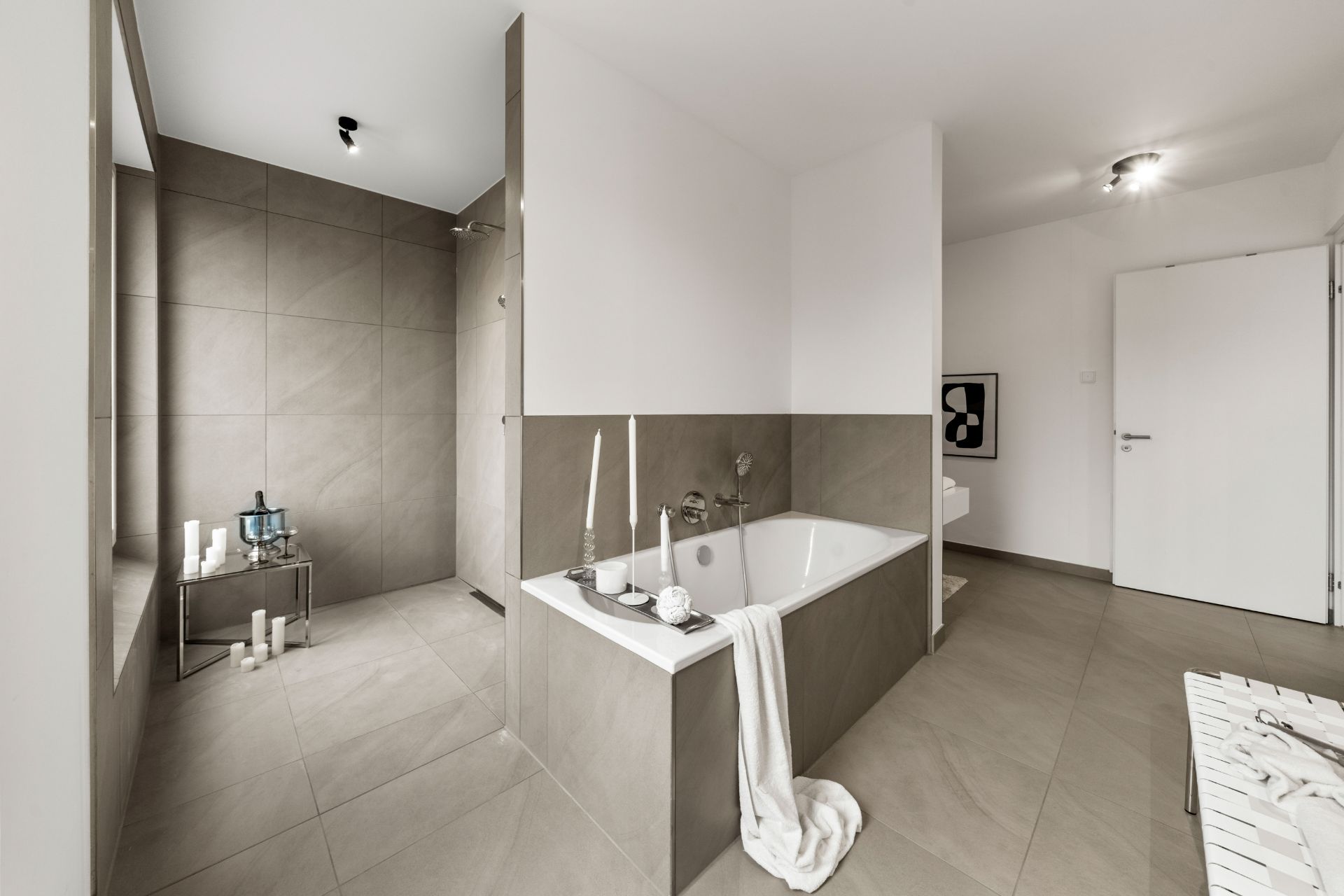 Modernes Badezimmer mit Badewanne, Dusche, weißen Wänden und beigen Fliesen.