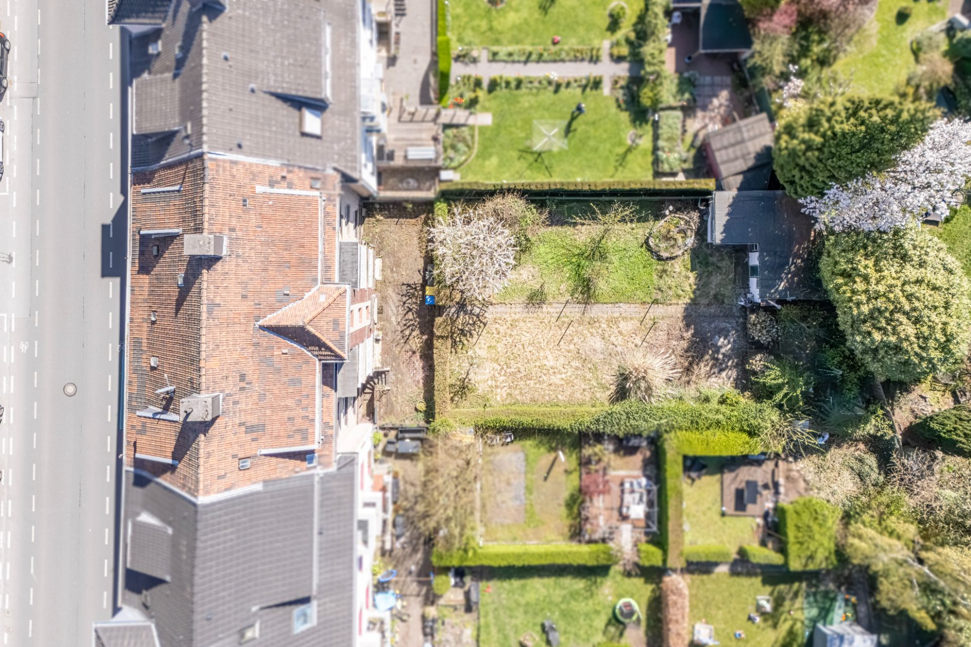 Luftaufnahme eines Wohnhauses mit angrenzendem Garten und benachbarten Grundstücken.