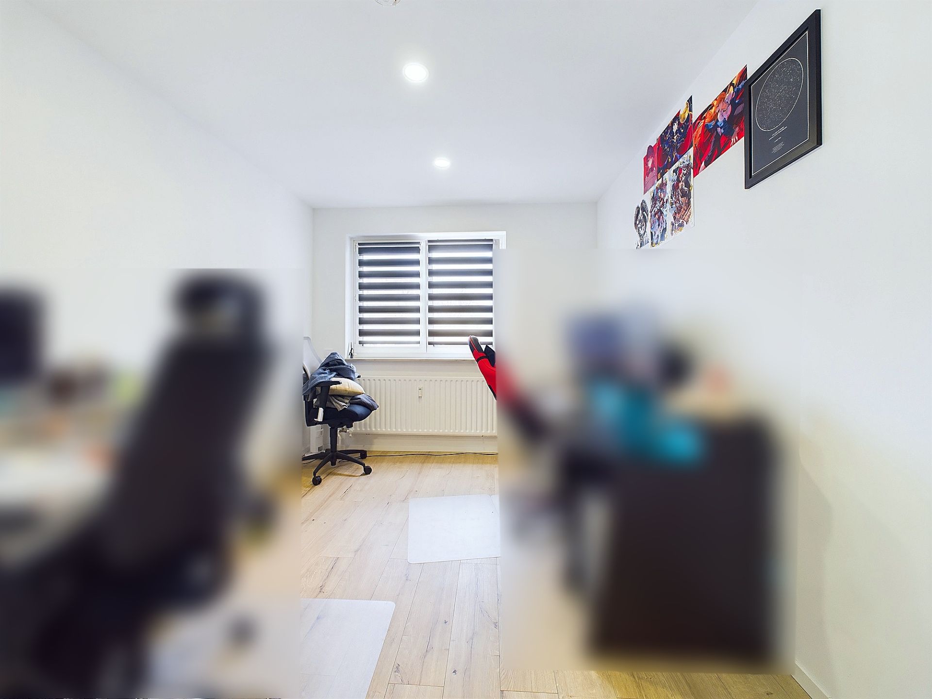 Helles Arbeitszimmer mit zwei Schreibtischen, Holzfußboden und Fenster mit Jalousien.