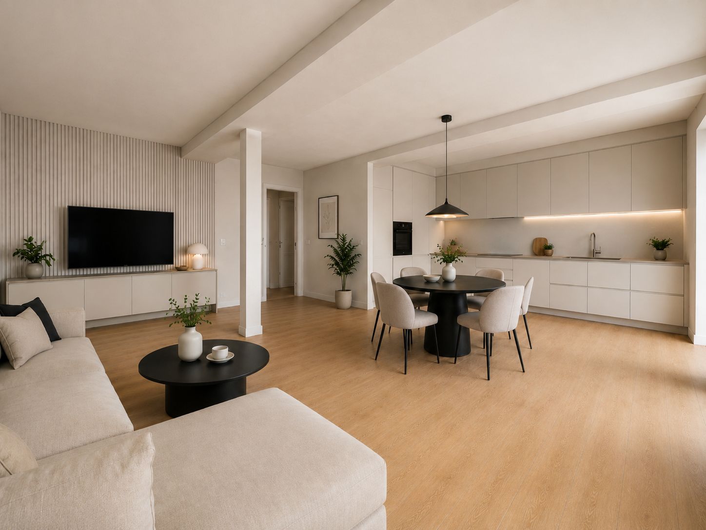 Modernes Wohnzimmer mit Sofa, Esstisch, offener Küche und Fernseher auf hellem Holzboden.