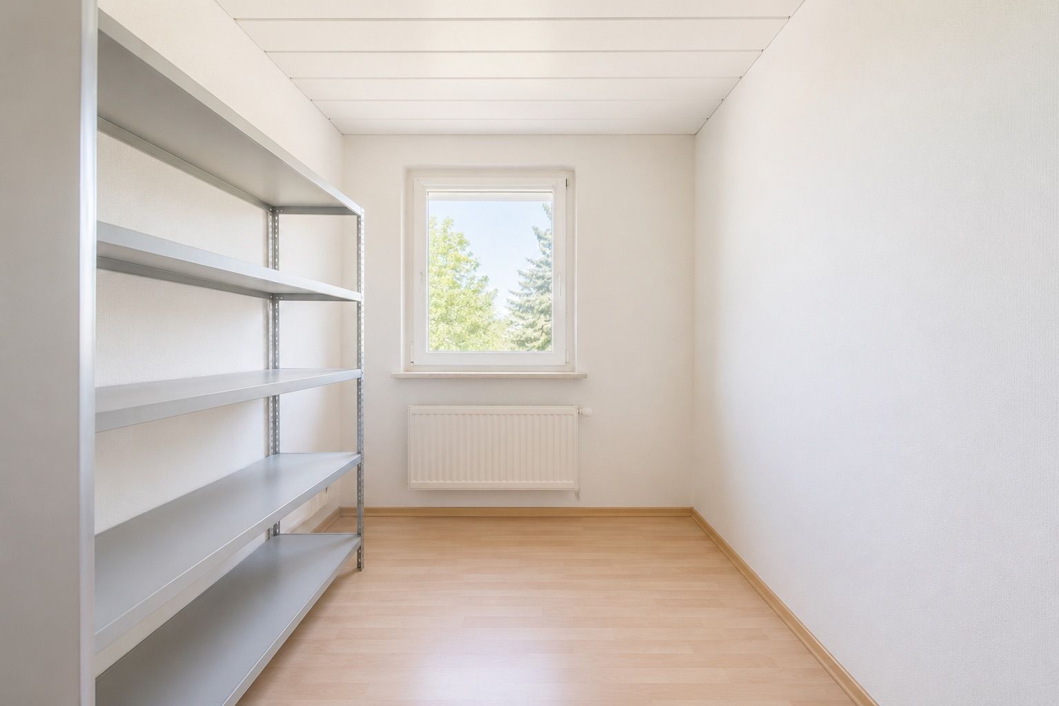 Helles, leeres Zimmer mit Metallregal, Fenster und Heizkörper, Laminatboden.