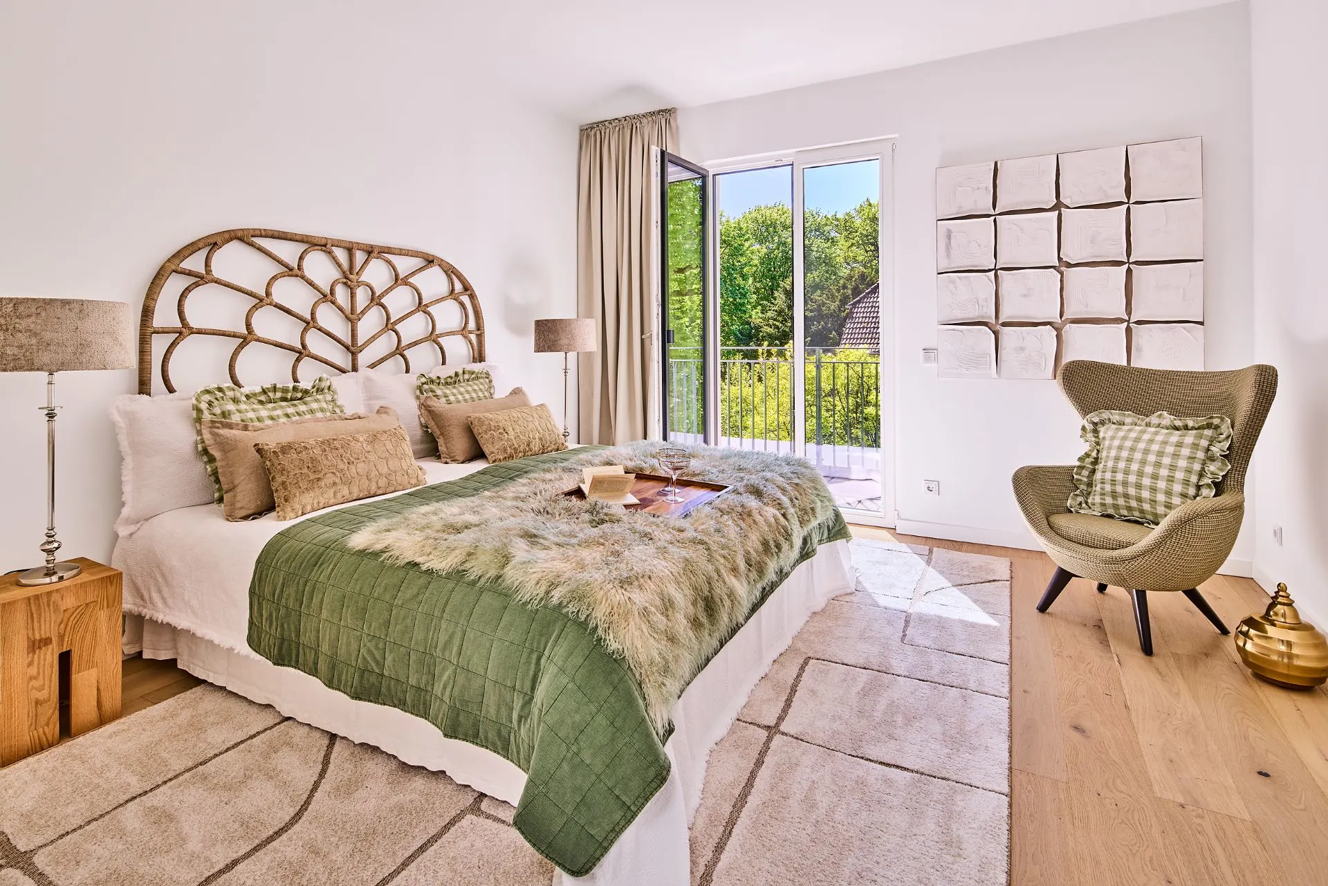 Helles Schlafzimmer mit Doppelbett, grünem Überwurf und Zugang zum Balkon.