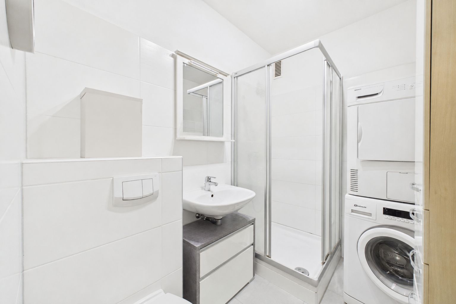 Modernes Badezimmer mit Dusche, Waschbecken, Waschmaschine und Trockner.