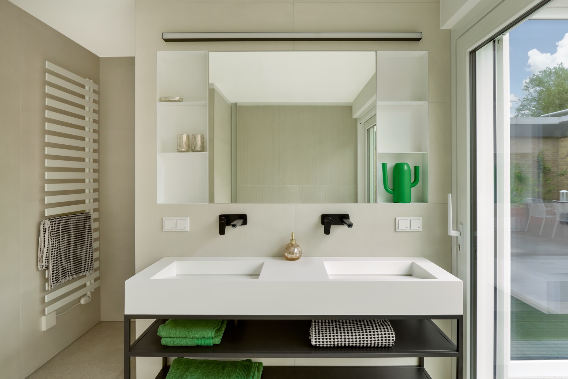Modernes Badezimmer mit Doppelwaschbecken, Spiegel und Handtuchheizkörper.