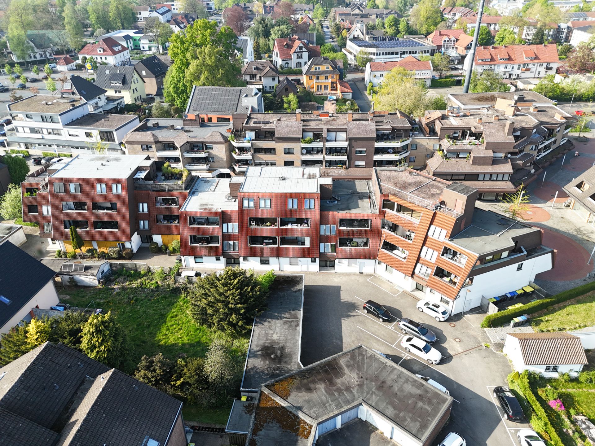 Luftaufnahme von Wohnhäusern mit Balkonen und umliegenden Straßen.