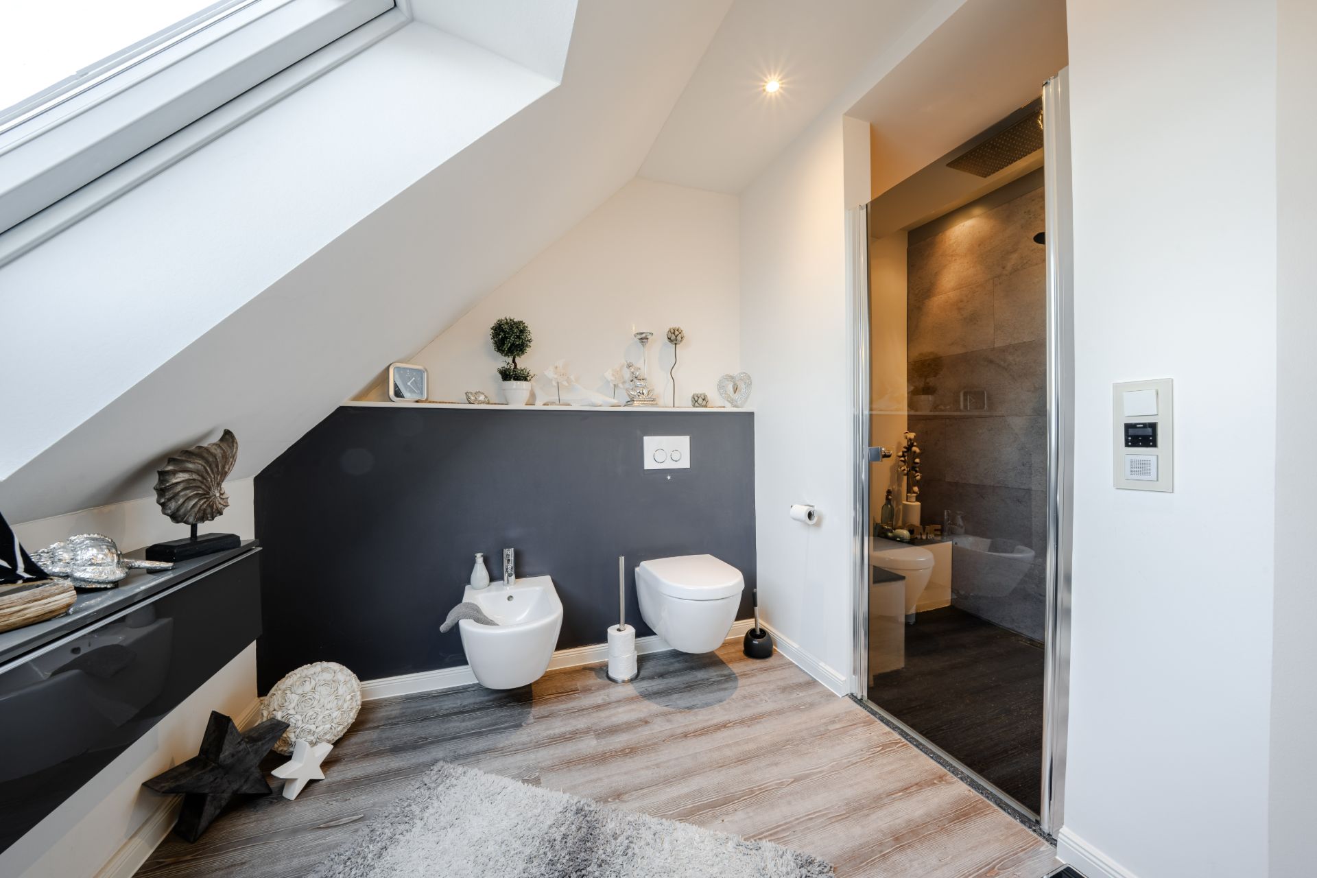 Modernes Badezimmer mit Dachschräge, WC, Bidet, Dusche und Dekorationen.