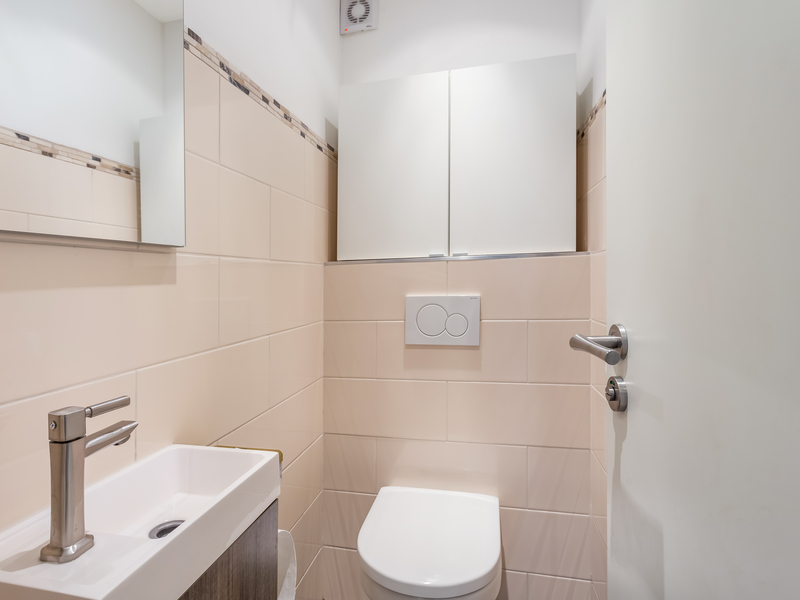 Kleines Badezimmer mit Toilette, Waschbecken und Spiegelschrank.