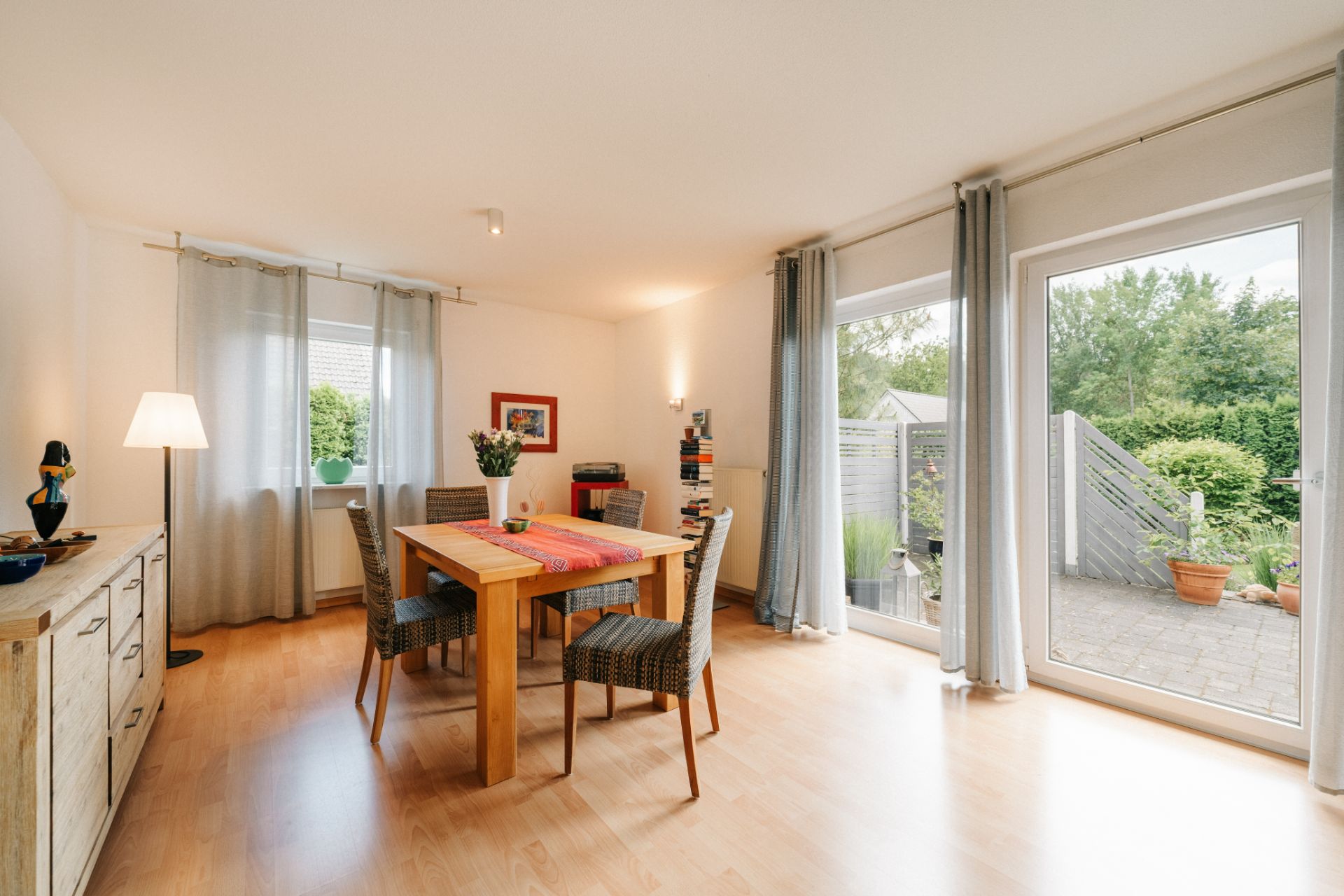 Helles Esszimmer mit Holztisch, vier Stühlen und Zugang zur Terrasse mit Gartenblick.