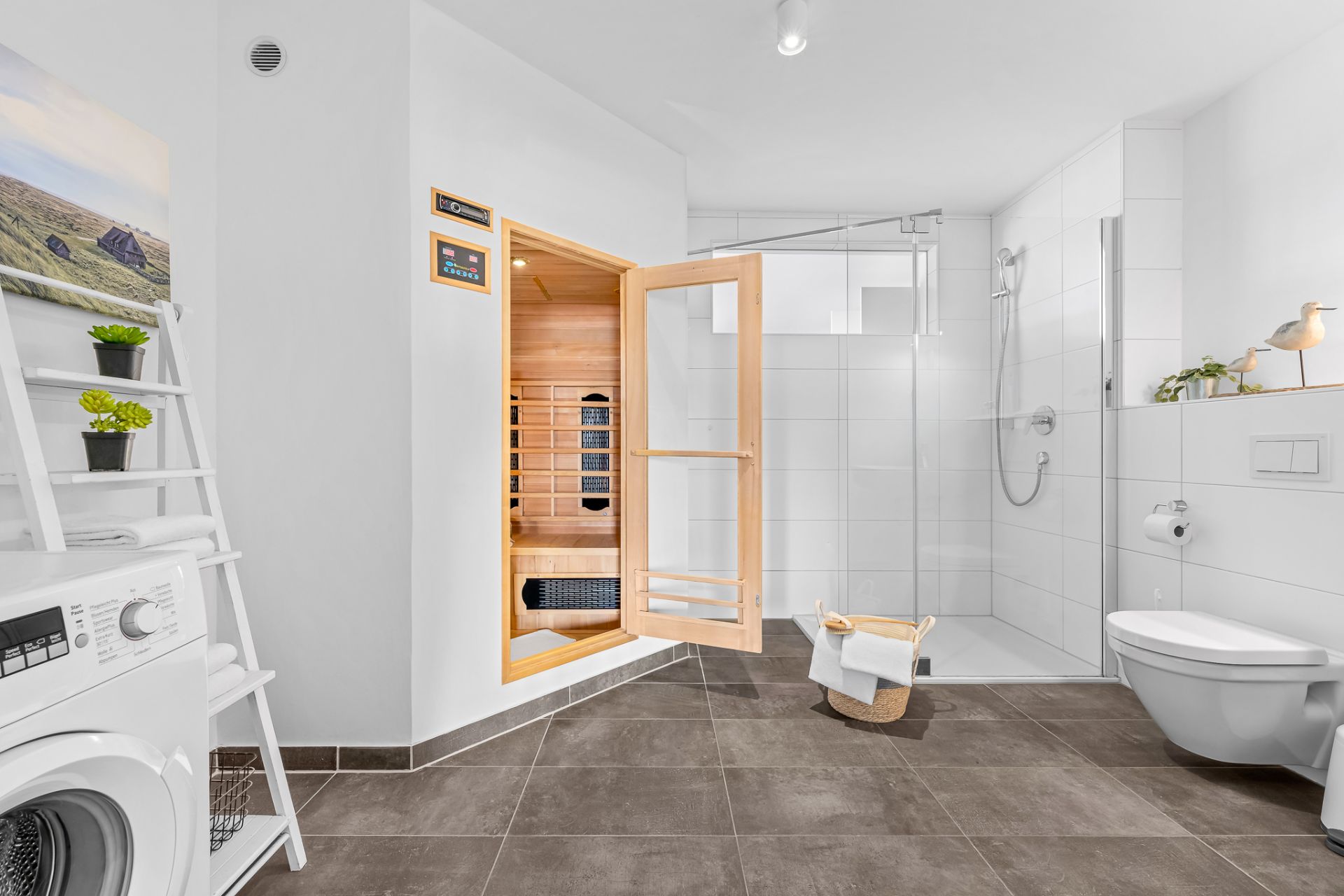 Modernes Badezimmer mit Sauna, Dusche, Toilette und Waschmaschine.