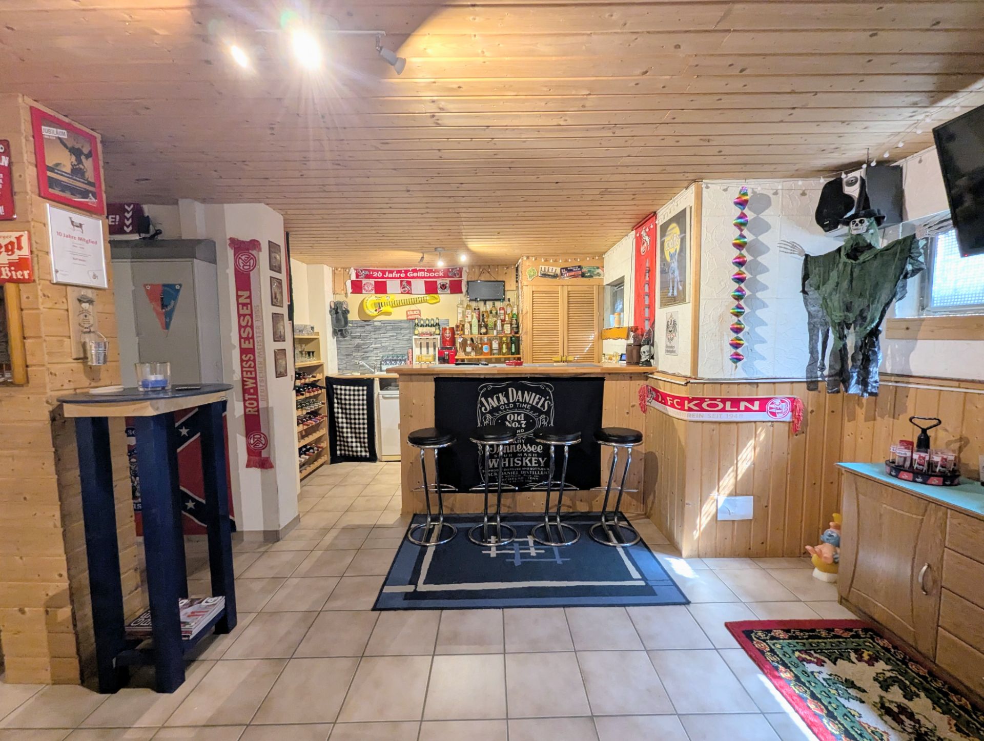 Gemütlicher Partyraum mit Bartresen, Barhockern und dekorierten Wänden in einem Wohnhaus.