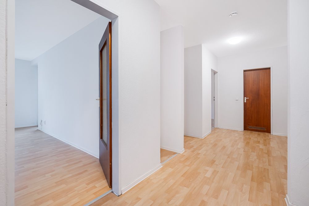 Heller Flur mit mehreren Türen und hellem Laminatboden in einer Wohnung.
