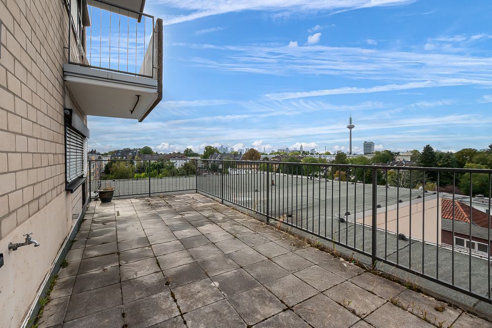 Große, geflieste Terrasse mit Metallgeländer und Blick auf Stadt und Fernsehturm.