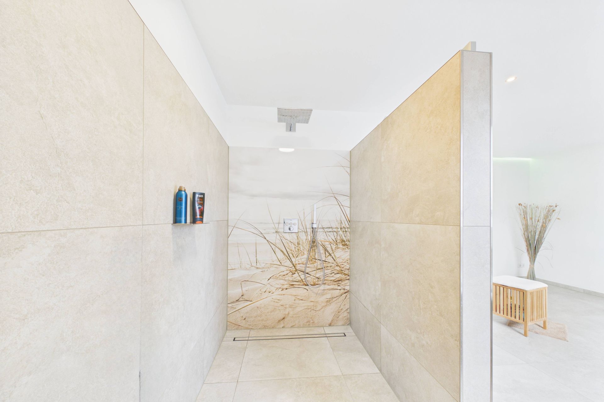 Große, offene Dusche mit Sandstrand-Motiv an der Wand und Regendusche an der Decke.
