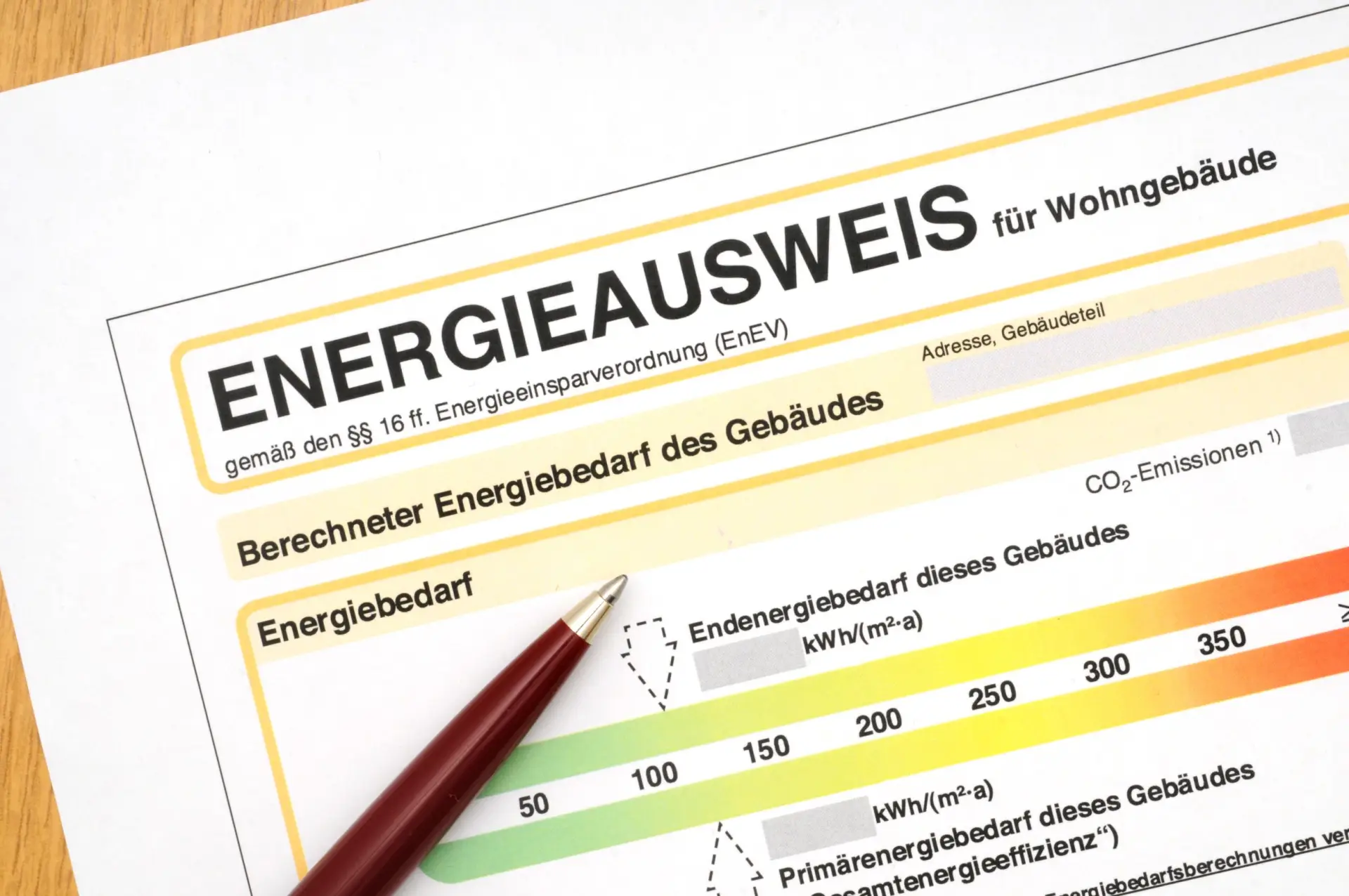 Ein Energieausweis für ein Wohngebäude mit einem Kugelschreiber auf dem Dokument.