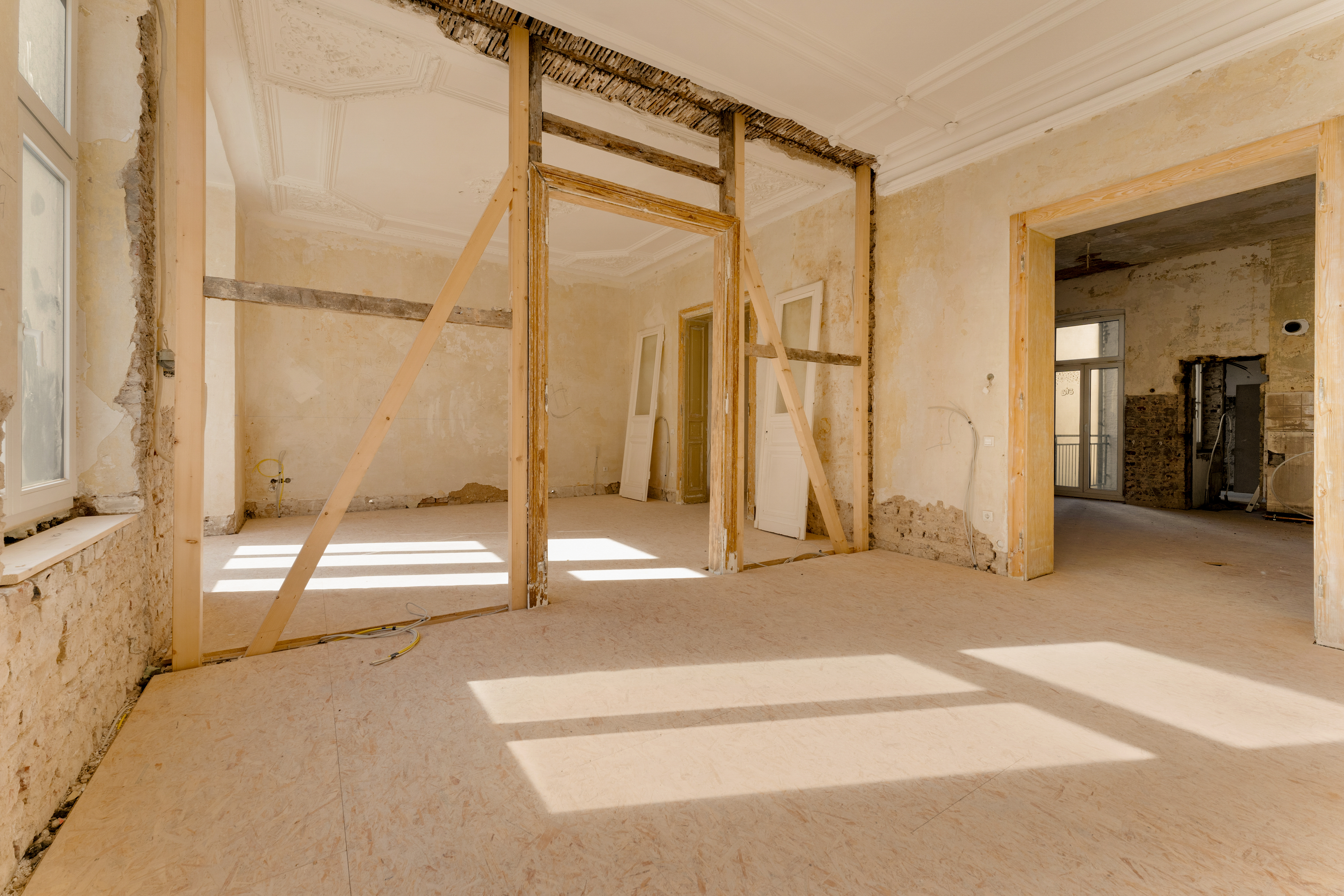Heller Raum in einem Wohnhaus mit Baustellencharakter, sichtbare Holzbalken und offene Wände.