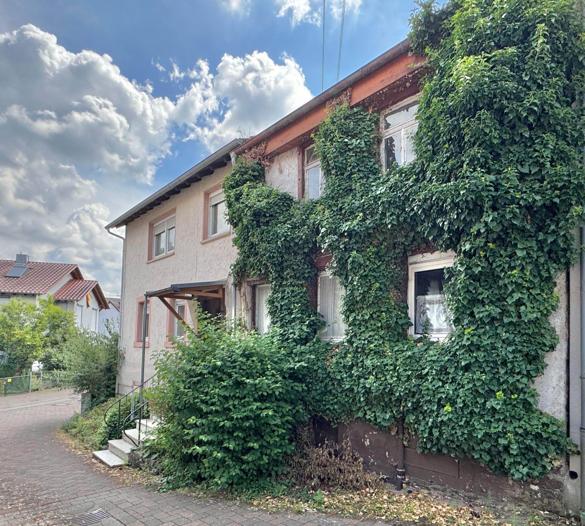 Wohnhaus mit Fassade, die stark von Efeu bewachsen ist.