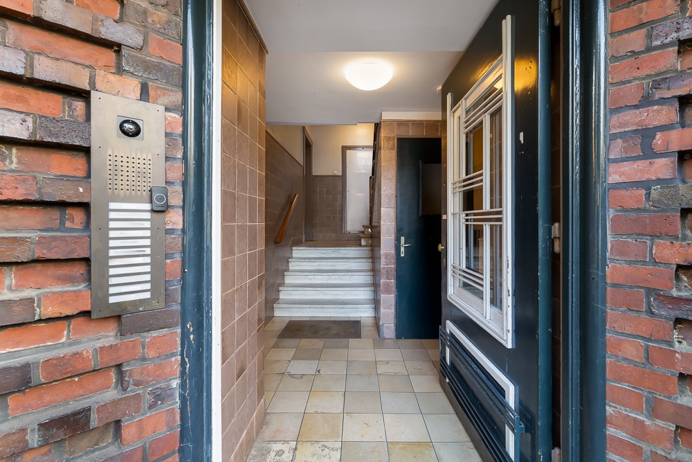 Eingang eines Wohnhauses mit Gegensprechanlage, Flur und Treppe.