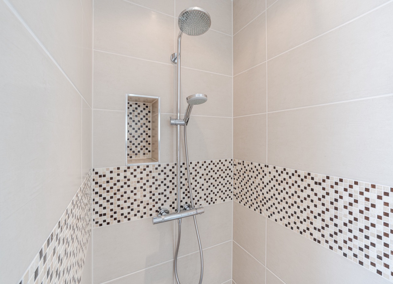 Moderne Dusche mit abgesetzten Mosaikfliesen und Regendusche.