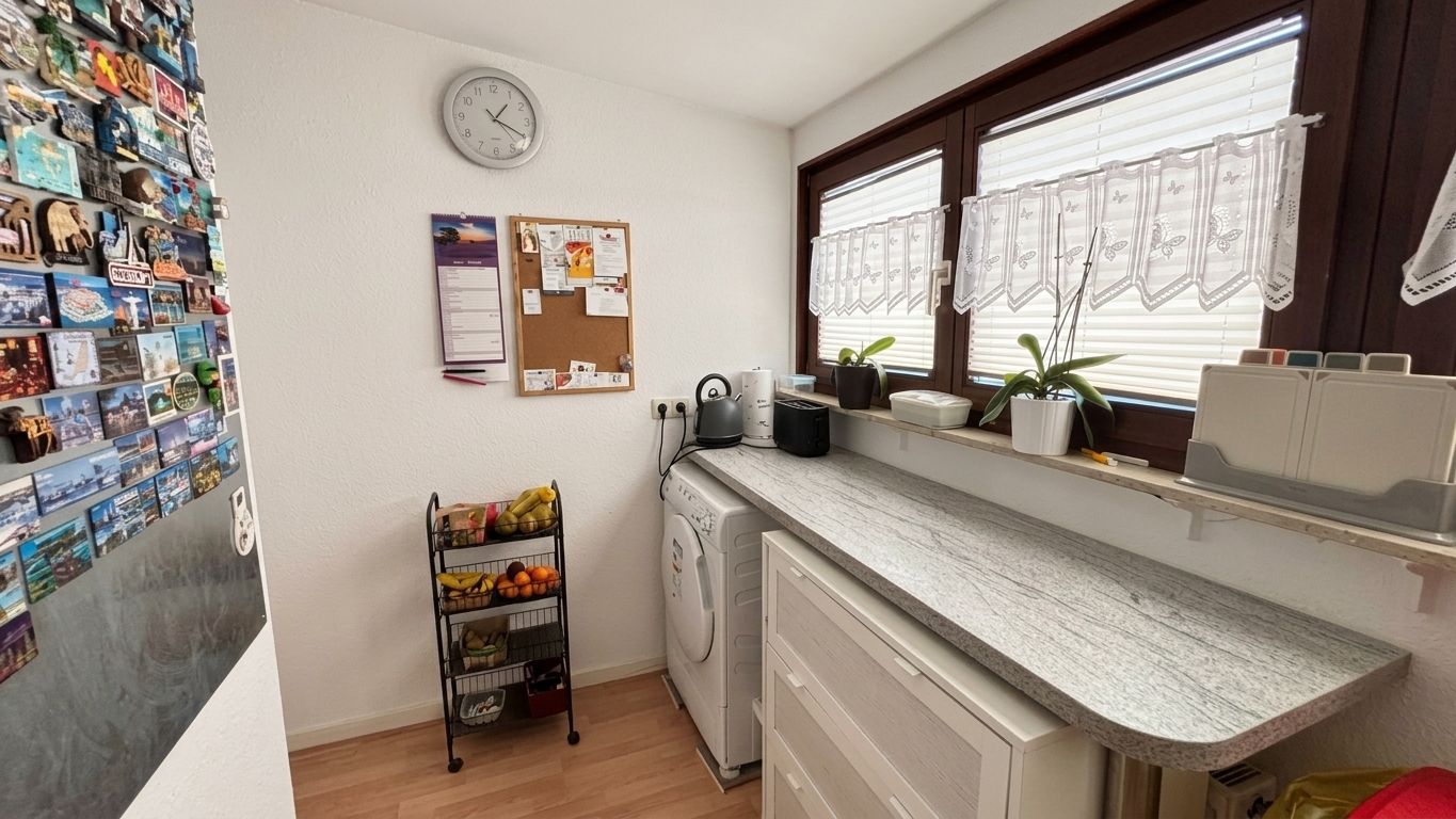 Waschküche mit Waschmaschine, Fenster, Pflanzen, Uhr, Magnetwand und Obstregal.