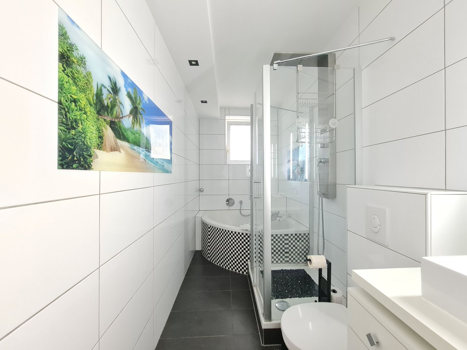 Modernes Bad mit Dusche, Badewanne und tropischem Wandbild, weiße Fliesen an den Wänden.